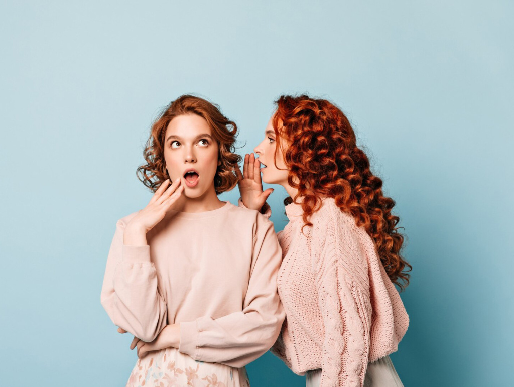 two-friends-sharing-gossips-studio-shot-girls-talking-blue-background_197531-17348.jpg